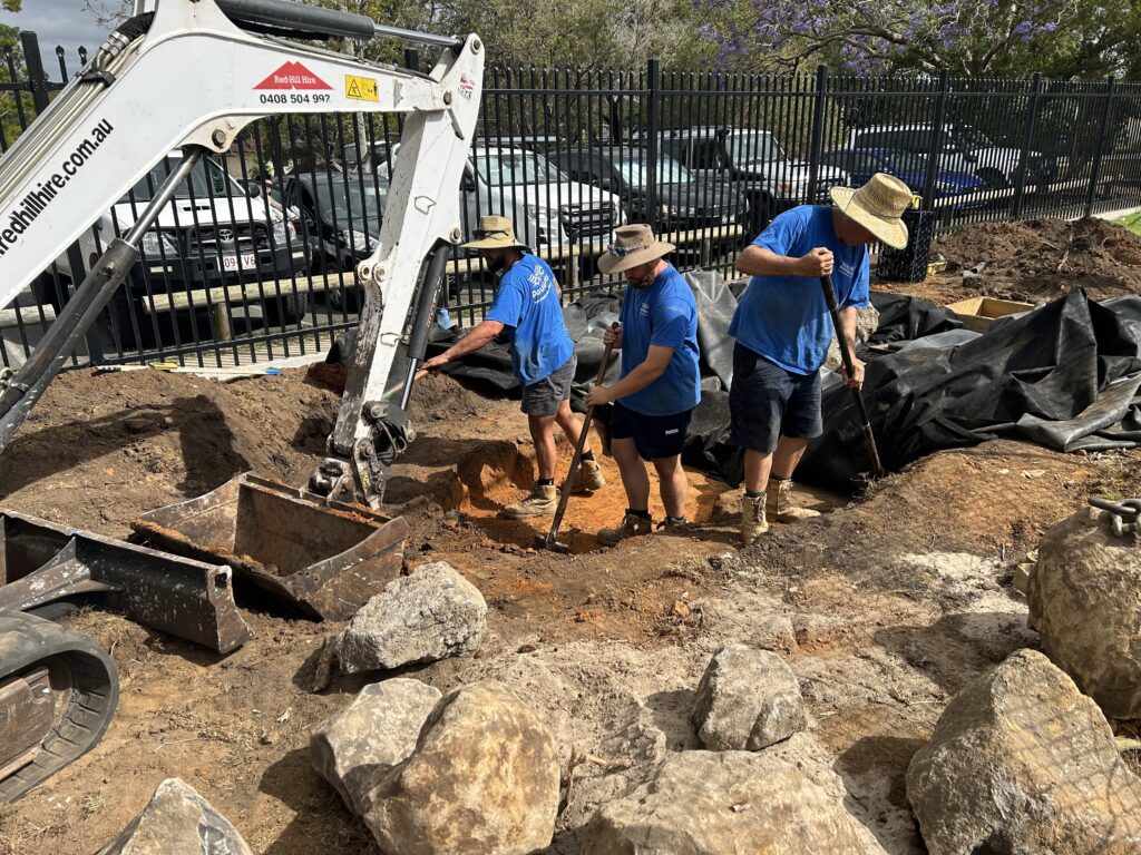 Pond Works team refining pond and stream excavation by hand at Kallangur State School after machine digging