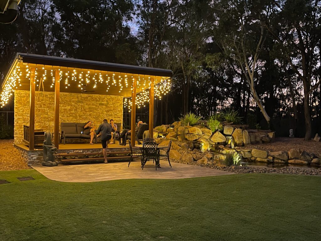 Bushside billabong water feature with twin waterfalls beside a timber gazebo-style entertaining area in Burbank, Queensland.