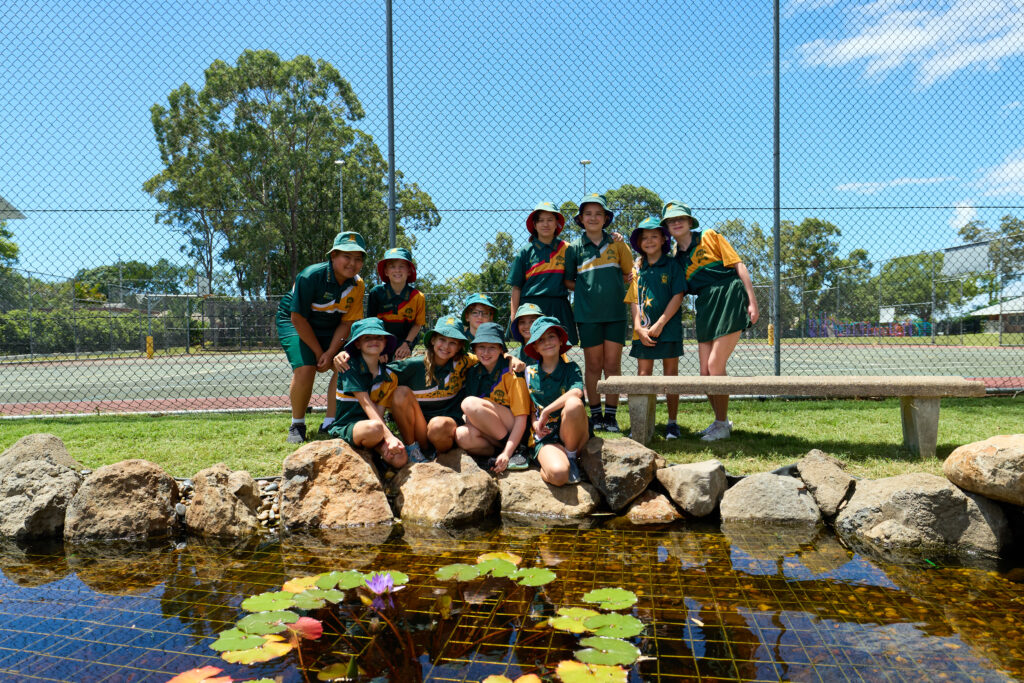Group photo of senior leaders at Kallangur State School standing beside completed pond and stream water feature