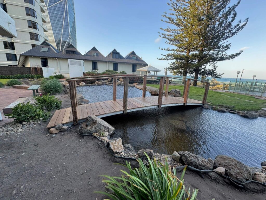 Steel-framed bridge with timber boards crossing a garden pond on the Gold Coast, Queensland