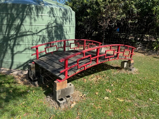Customer's existing bridge incorporated into a Japanese-inspired pond designed by Pond Works